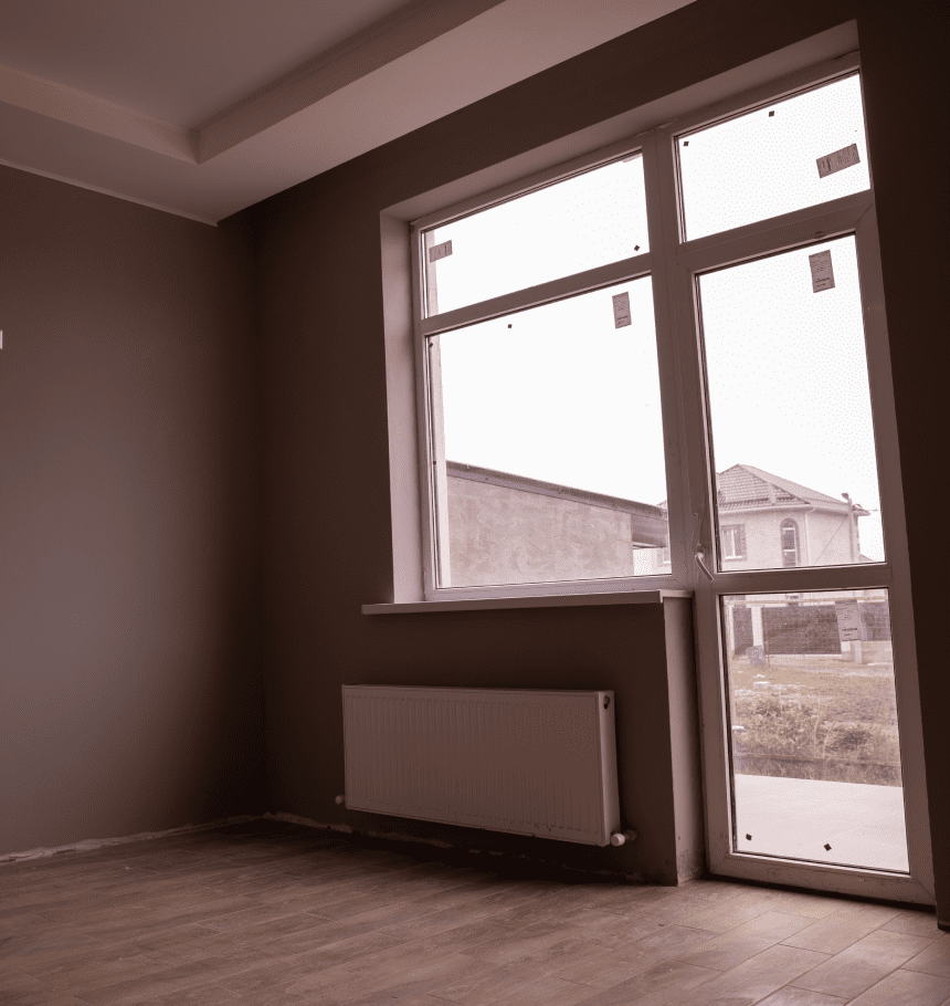 Empty room with large window and radiator.